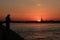 Silhouette of a fisherman on the bank of a river