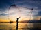 Silhouette of fisherman casting fishing net into the sea