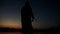 Silhouette fisherman catching fish on rod on background evening sunset