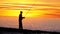 Silhouette of a Fisherman with a Fishing Rod at Sunset over the Sea
