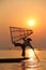 Silhouette of a fisherman near lake catching fish in a traditional way with a handmade net at sunset