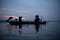 Silhouette of fisherman at sunrise, Standing aboard a rowing boat and casting a net to catch fish