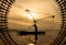 Silhouette of fisherman at sunrise, Standing aboard a rowing boat and casting a net to catch fish