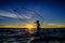 Silhouette fisherman trowing the net at the lake in the sunset,
