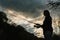 Silhouette of a fisherman. Young woman fishing on a lake at sunset. Fishery, fishing day. Rod rings, fishing tackle. Fisherman