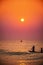 Silhouette of Fishermen coming back by boat to sea beach during early morning Sunrise time from the ocean.