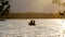 Silhouette of fishermen fishing in a motor boat on a lake at sunset.
