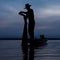 silhouette of fishermen using nets to catch fish at the lake