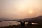 The Silhouette of fishing boat, outdoor chair, mountain and sun