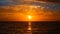 A silhouette of a fishing ship boat at the horizon seascape floating under the setting sun, colorful evening twilight