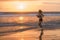 Silhouette of fit and athletic Asian Chinese sporty woman running on beautiful beach doing jogging workout on sunset in fitness he