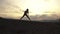 Silhouette of fit muscular woman stretching outdoor on sunset. Fitness concept