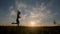 Silhouette of a fit woman girl running at sunset. Training, jogging, healthy lifestyle.