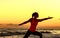 Silhouette of fit woman in sport clothes on beach stretching