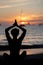 Silhouette of Fitness model doing yoga at sunset time