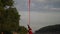 Silhouette of Flexible female acrobat doing crazy and dangerous trick on red aerial silk the sunset sky background is