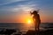 Silhouette of flexible girl with dreadlocks on ocean coast