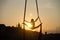 Silhouette of a flexible woman acrobat on aerial silk during a sunset on Kiev city background. concept of freedom and