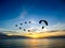 silhouette flying birds and paramotor over sea sunset sky