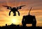 Silhouette flying reconnaissance drone over city and hand remote control