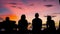 Silhouette of four men travelers chilling and chatten with an other at the Pier during gorgeous sunset, Kri Island. Raja