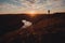 Silhouette of a free man enjoying freedom, feeling happy at sunset. A serene relaxing man on the edge of a cliff.