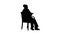 Silhouette Friendly senior woman sitting in chair reading a book.