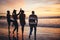 Silhouette, friends and at the beach or sea relax, happy and have fun with sunset view on vacation together. Group, men