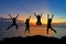 Silhouette of friends and teamwork jumping on beach during sunset time for success business.