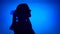 Silhouette of frustrated woman cry. Female`s face in profile scream in despair on blue background