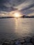 Silhouette of Galway hooker type wooden boat sailing from harbor at stunning sunset time. Hobby and water sport. Dark and moody