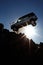 silhouette of a generic car crashing flying off a cliff. Stone cliff. Blue sky. sun rays. Car accident.