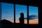 Silhouette of a girl against sunset on the window mountains view