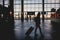 Silhouette of a girl at the airport with suitcase and backpack