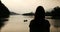 Silhouette of a girl on a background of lake and boat