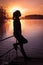 Silhouette girl background sun. Girl standing near water outdoors. Gold sunset lake. Young woman thinking about something river du