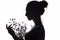 Silhouette of girl with a bouquet of with dandelions, young woman face on a white isolated background