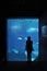 Silhouette of a girl in front of aquarium