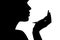 Silhouette of a girl with handpicked hair, profile of a woman face looking in a pocket mirror, the concept of the beauty and fashi