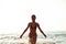 Silhouette of girl having fun in Baltic sea splashing waves