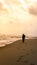 Silhouette of an girl with hijab walking alone leaving her footprint on sand behind at the beach