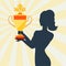 Silhouette of girl holding prize cup