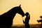 Silhouette of girl with horse at the sunset