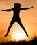 Silhouette of a girl jumping at sunset