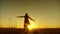 Silhouette of girl with long disheveled hair jumping in flight in bright light of setting sun. Free and romantic woman