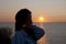 Silhouette of girl look at romantic sunset sun and sky with seascape. copy space