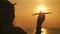 Silhouette girl plays with a toy airplane on tropical beach at sunset. Hand with small plane close up. Relax time on