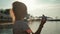 Silhouette girl plays with a toy airplane on tropical beach at sunset. Hand with small plane close up. Relax time on