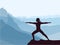 Silhouette of girl practicing yoga. Blue mountains in background