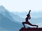 Silhouette of girl practicing yoga. Blue mountains in background